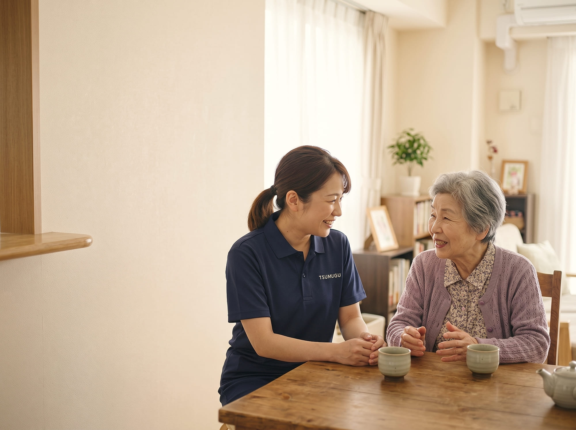 ヘルパーとご利用者さまがお茶を飲みながら笑顔で話している様子